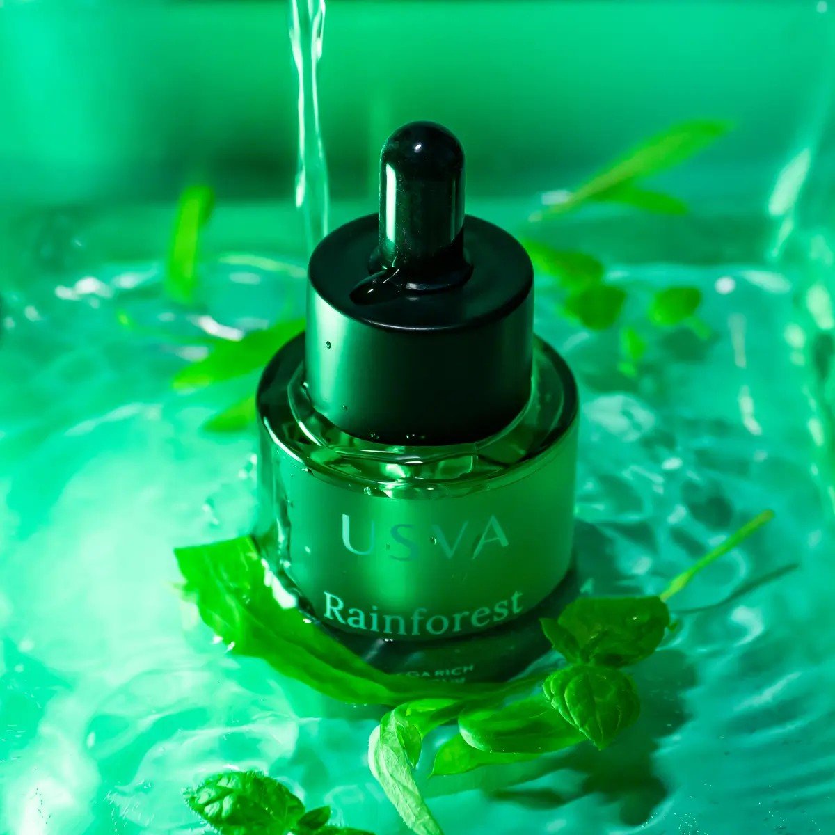4. Usva Cosmetics Rainforest Omega Rich Oil Serum bottle surrounded by water and green leaves