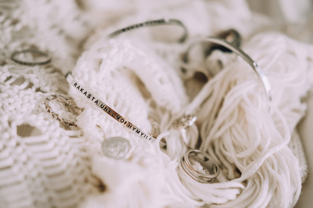 5. Close-up of Olla SEURAA UNELMIASI bracelet in silver with engraved message, styled with accessories