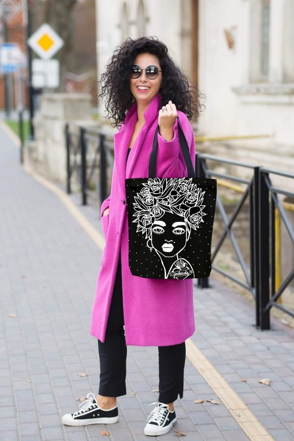 5. Woman in pink coat carrying Garbanota Naomi handbag with floral haircut design in black, street style