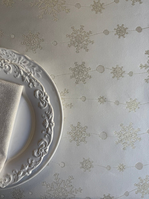 5. Flat lay of tablecloth with golden snowflake design and ornate plate with napkin