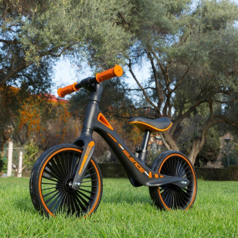 1. Feber balance bike on grass with trees in the background