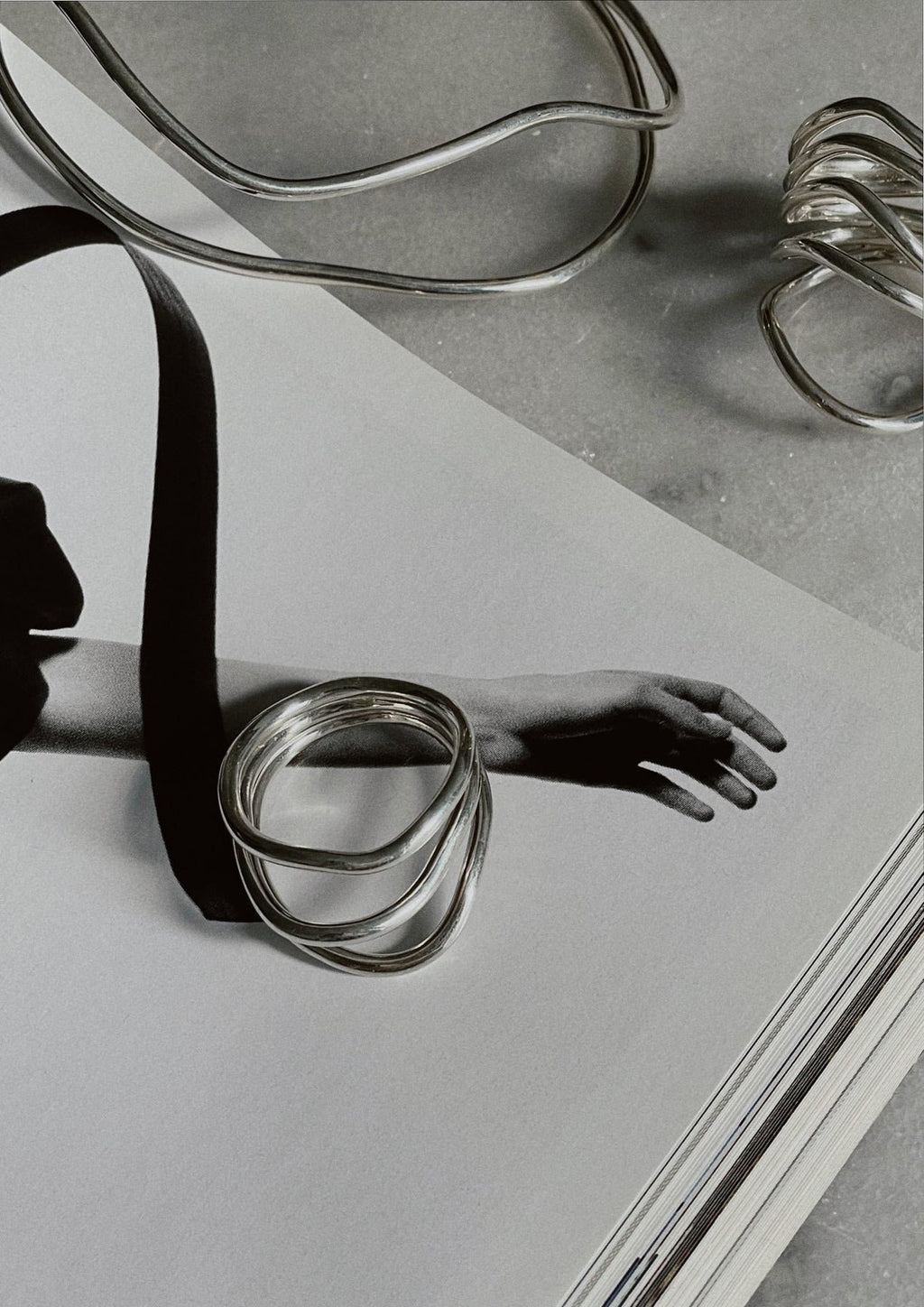 4. Artistic display of NO MORE Reef Break Wave Ring in sterling silver on a magazine page