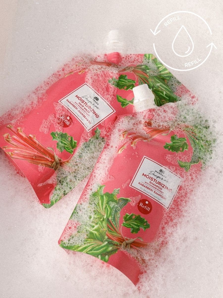 2. Two Magrada Organic Cosmetics rhubarb shampoo refill packs in a bubbly setting, highlighting eco-friendly packaging