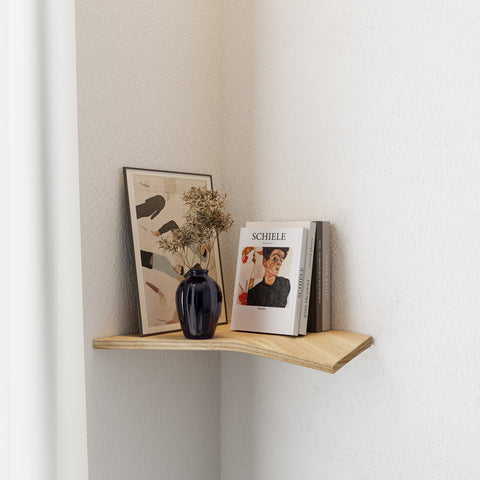 1. Wooden corner shelf in natural oak finish mounted in a living room corner, displaying a vase, framed art, and books