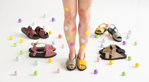 1. Women's Berlin sandals in green by Omaking, shown in a playful lifestyle setting with colorful polka dots and other sandal styles