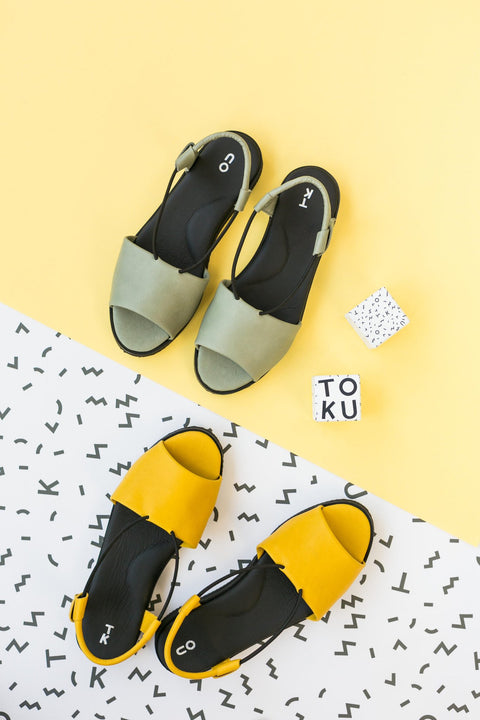 2. Green and yellow Berlin sandals by Omaking displayed on a vibrant background with geometric patterns