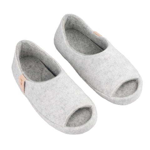 2. Studio image of unisex TOKU Bern white slippers by Omaking, featuring open-toe design and natural lambswool felt