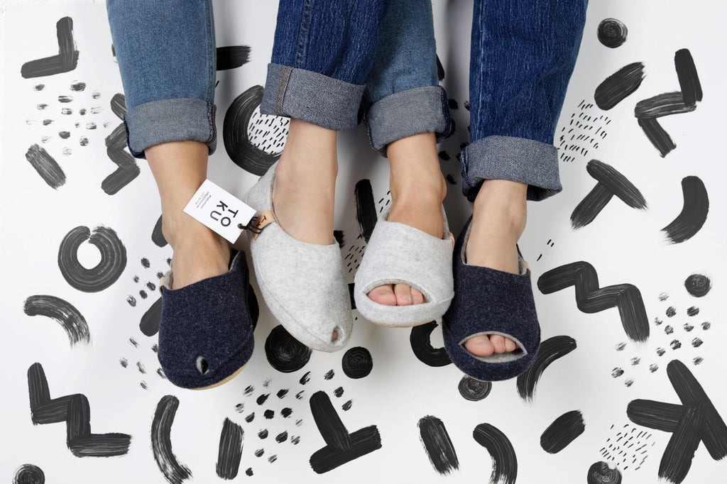 1. Unisex TOKU Budapest slippers in dark grey and light grey worn by models, showcasing cozy design and style