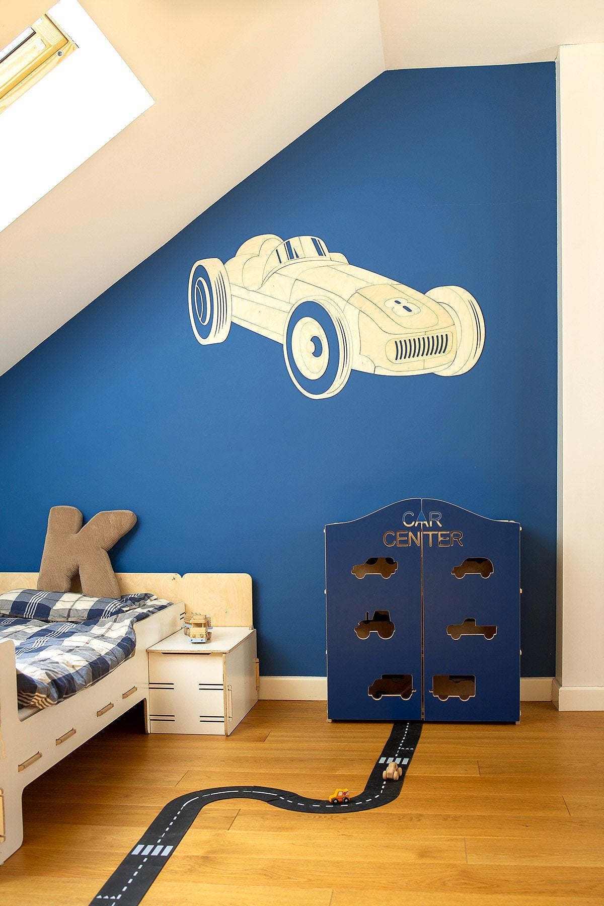 3. Wooden retro car wall decoration on blue wall in children's room with bed and play area