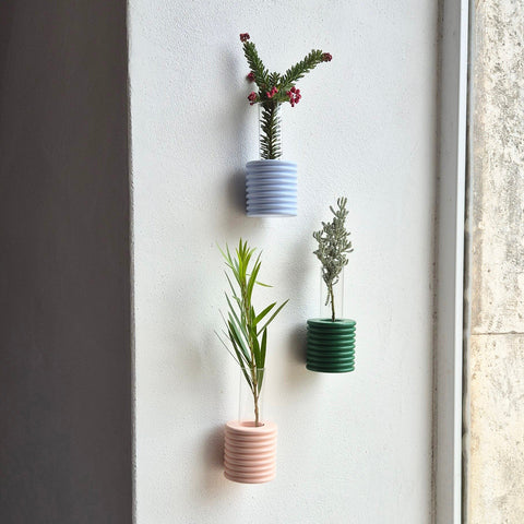 3. Trio of Ribble Wall Vases in light blue, green, and pink, displayed with plants on a wall