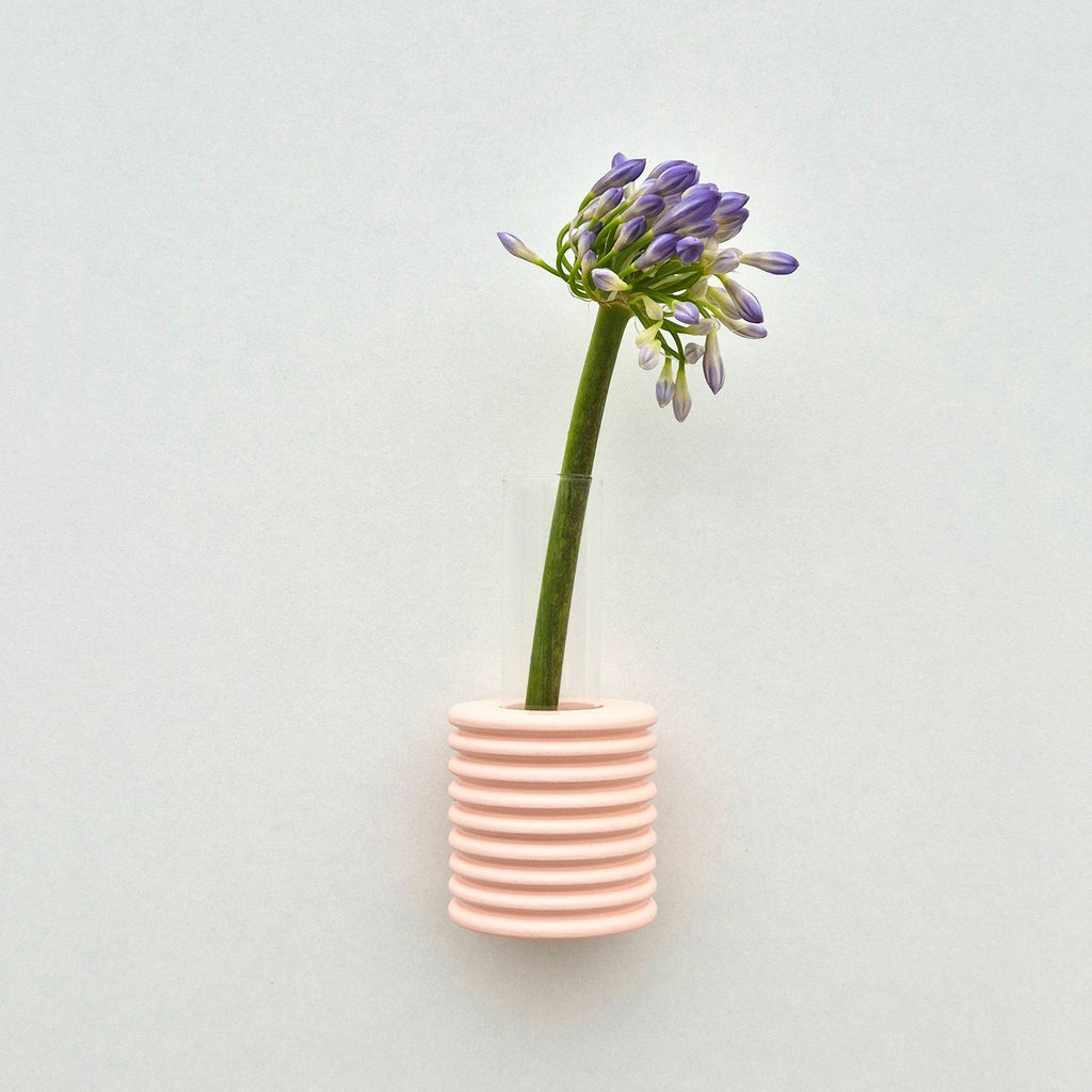 1. Ribble Wall Vase in pink by 5mm Paper with purple flower, showcasing playful design and natural beech wood finish