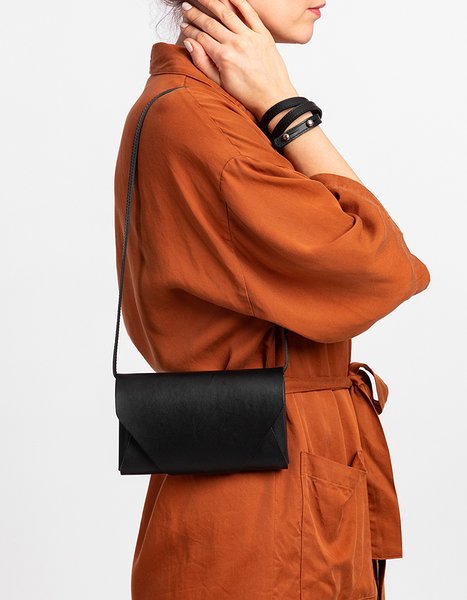 10. Woman wearing black leather Stella Soomlais Capital of Plenty clutch-wallet crossbody with orange jacket