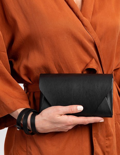 13. Woman holding black leather Stella Soomlais Capital of Plenty clutch-wallet in hand
