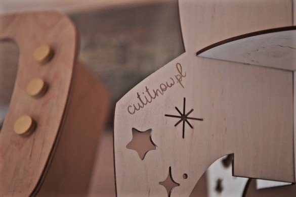 5. Close-up of Cut It Now logo and star cut-out on wooden rocket shelf