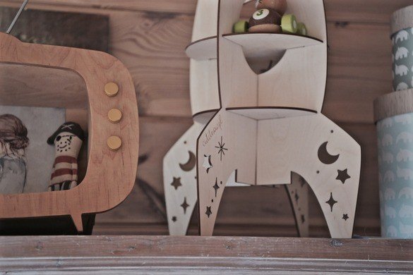 6. Detail of Cut It Now rocket-shaped wooden shelf with star and moon cut-outs on wooden surface