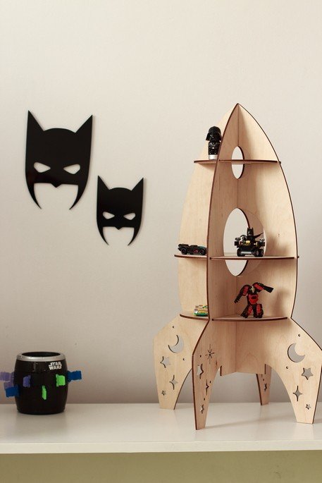 4. Rocket-shaped wooden shelf by Cut It Now on white surface with black wall decor