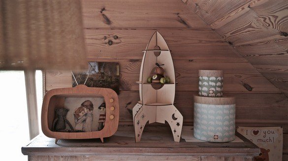 2. Rocket-shaped wooden shelf by Cut It Now on wooden dresser with vintage decor in cozy room