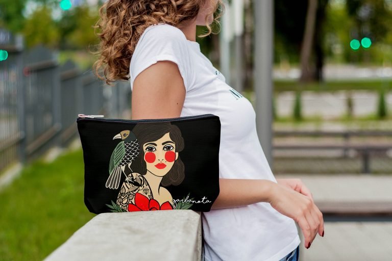 1. Woman holding Garbanota Makeup Bag/Pouch Rose in Black with artistic print, lifestyle setting