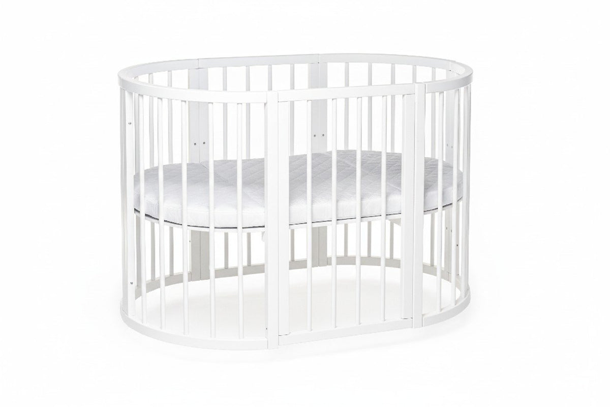 7. White round baby crib with orthopedic slatted base for airflow, shown in a studio