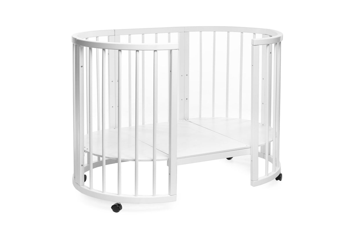 16. White round baby crib with lockable wheels, shown in a studio setting