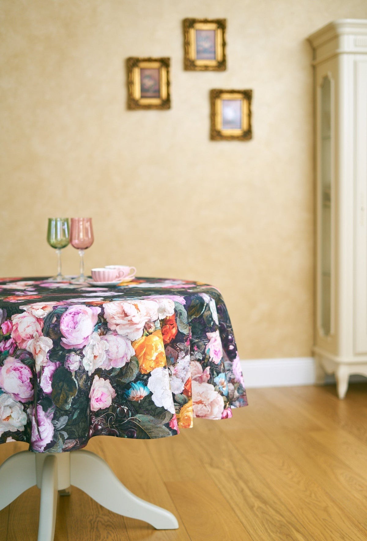 4. Round table with Francine black floral tablecloth in classic dining room with framed pictures on wall