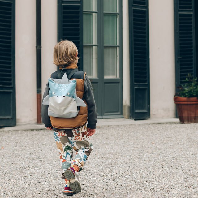 1. Child wearing Muni shark backpack outdoors, showcasing playful design and adjustable straps