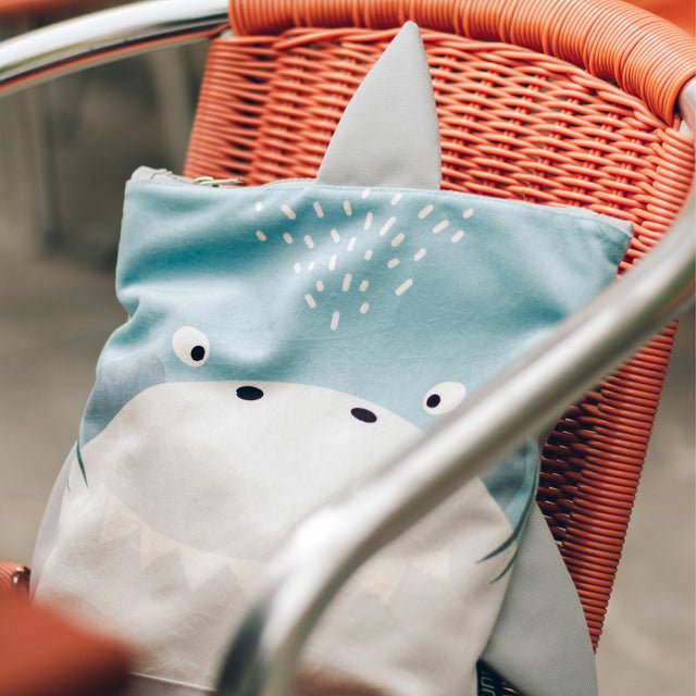 8. Muni shark backpack on chair, showcasing unique shark-inspired design
