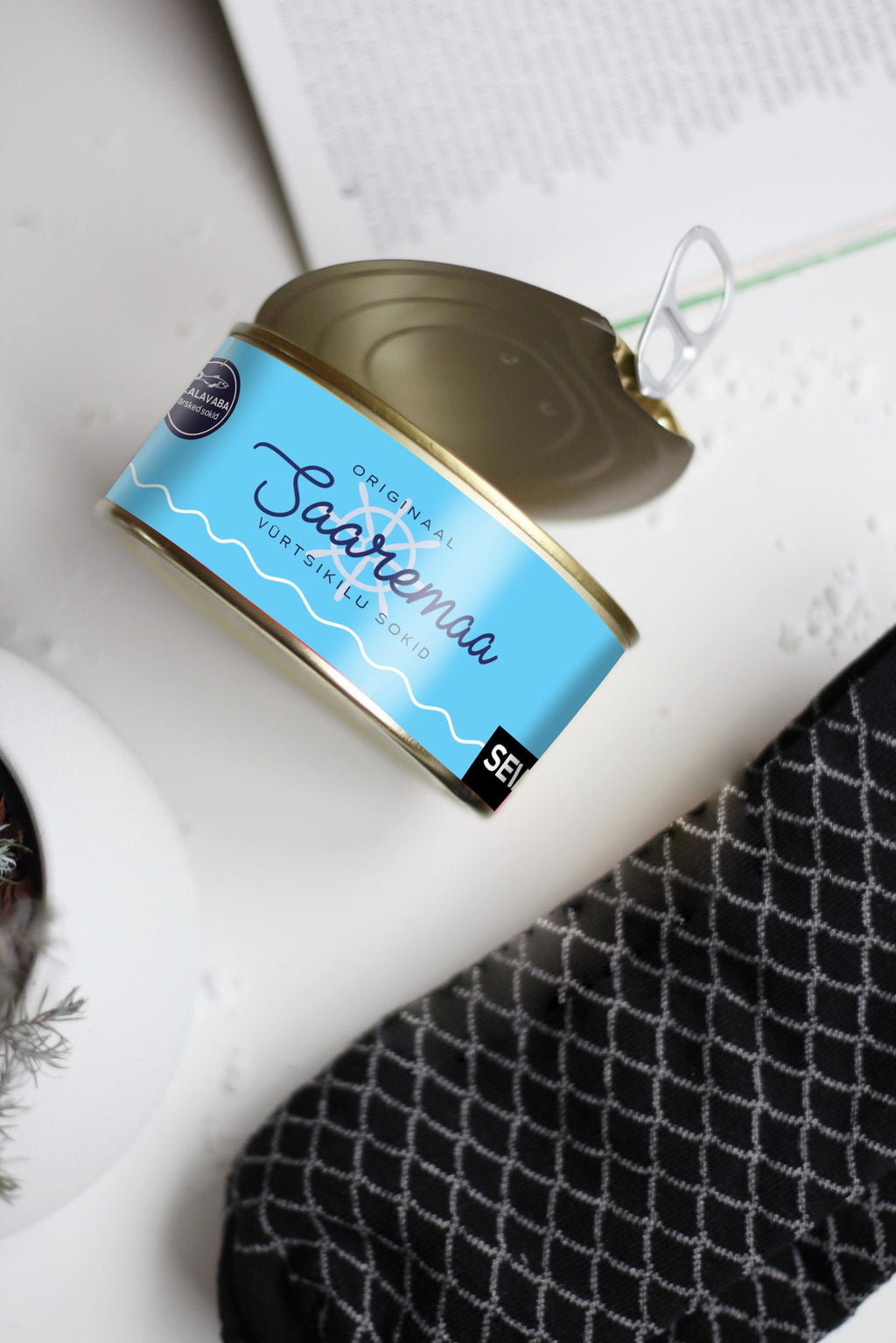 12. Saaremaa Vürtsikilu Socks tin with opener, styled with black patterned socks and book