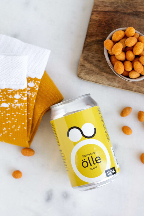 4. Flat lay of SEIK Saaremaa öllesokid with can and snacks, showcasing product and packaging