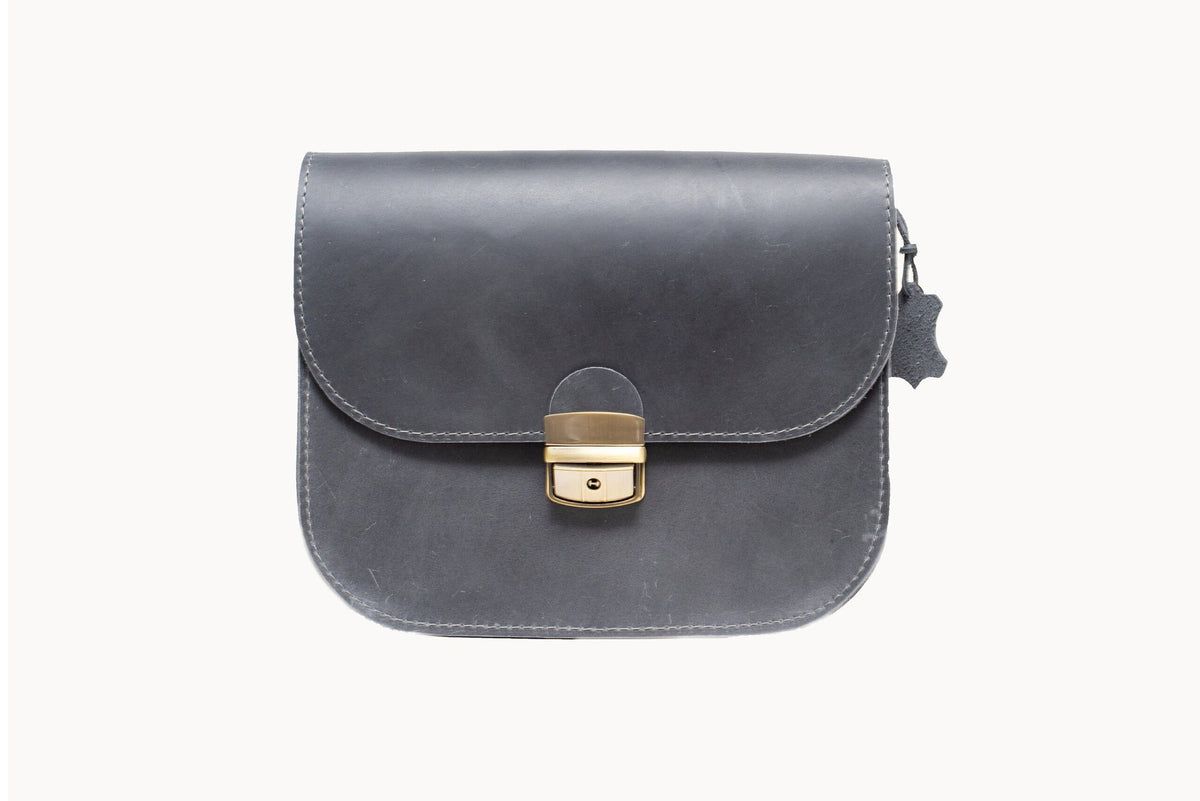 3. Studio shot of Zelma Kraft grey leather saddle bag with buckle closure and adjustable strap