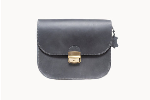 3. Studio shot of Zelma Kraft grey leather saddle bag with buckle closure and adjustable strap