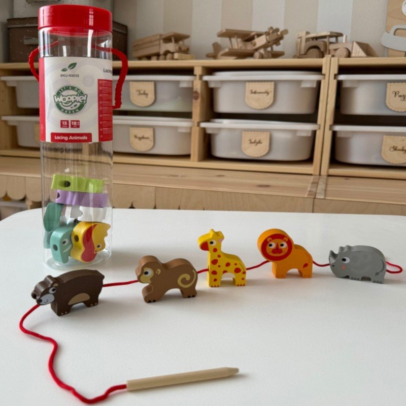 4. Safari animal shaped wooden threading blocks with red string and packaging on a table