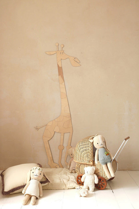 4. Wooden giraffe wall decoration in child's room with plush toys and wicker basket on beige wall