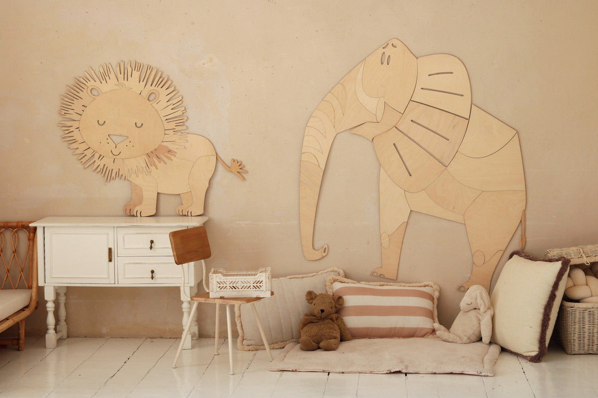 6. Wooden lion and elephant wall decorations in a children's room with white furniture and plush toys