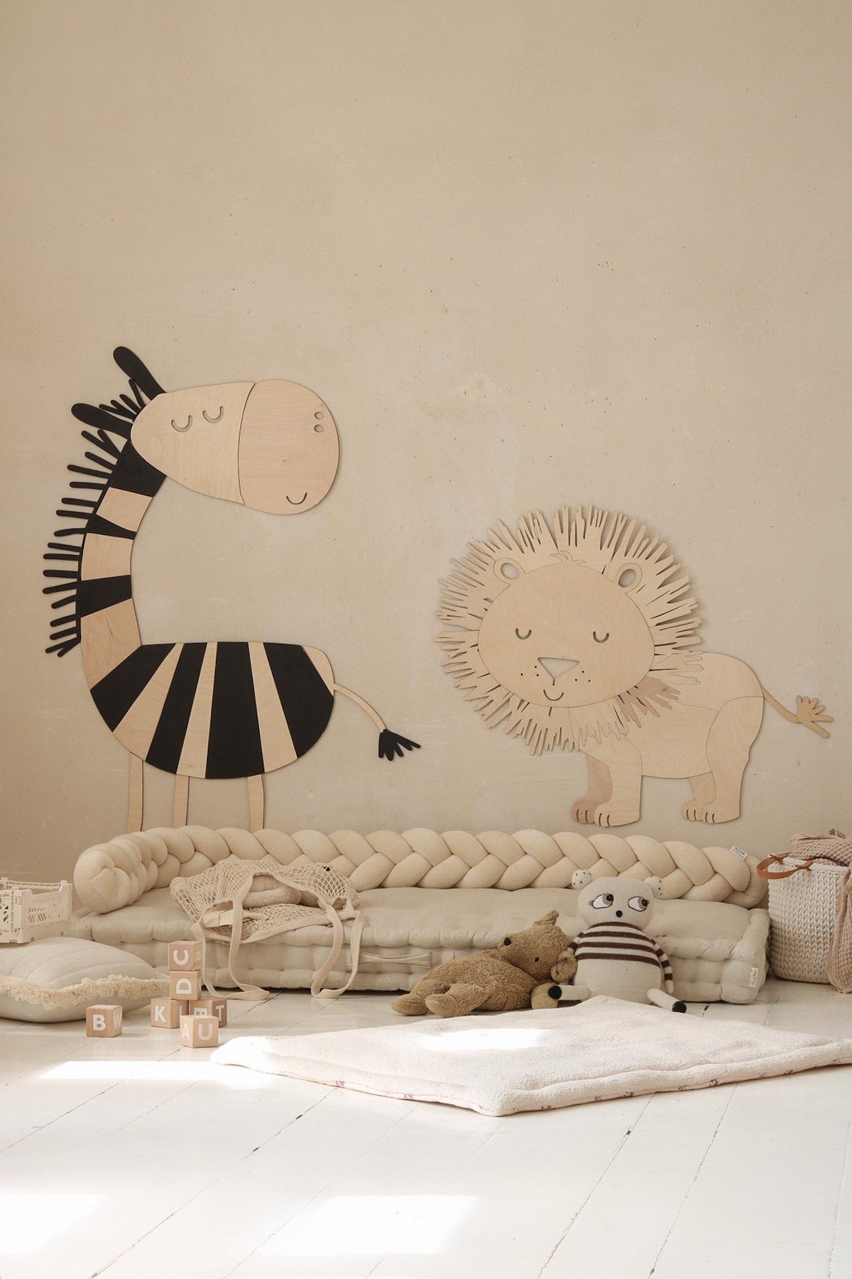 2. Wooden lion and zebra wall decorations in a children's room with toys and cushions