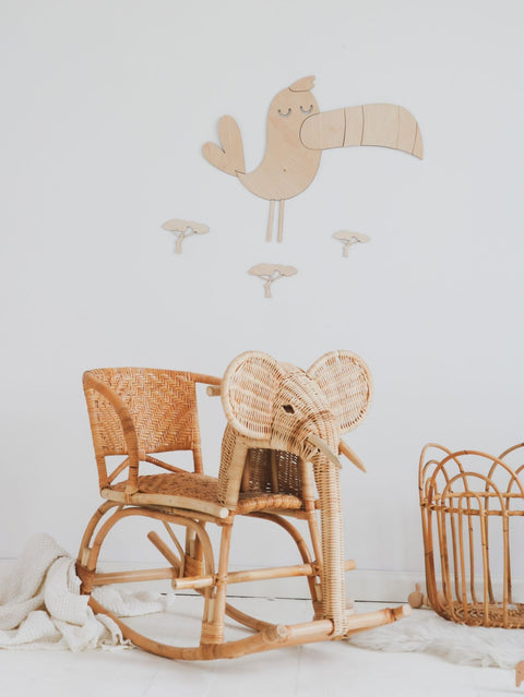 1. Wooden toucan wall decoration in a nursery setting with wicker elephant rocking chair and basket, creating a playful safari theme