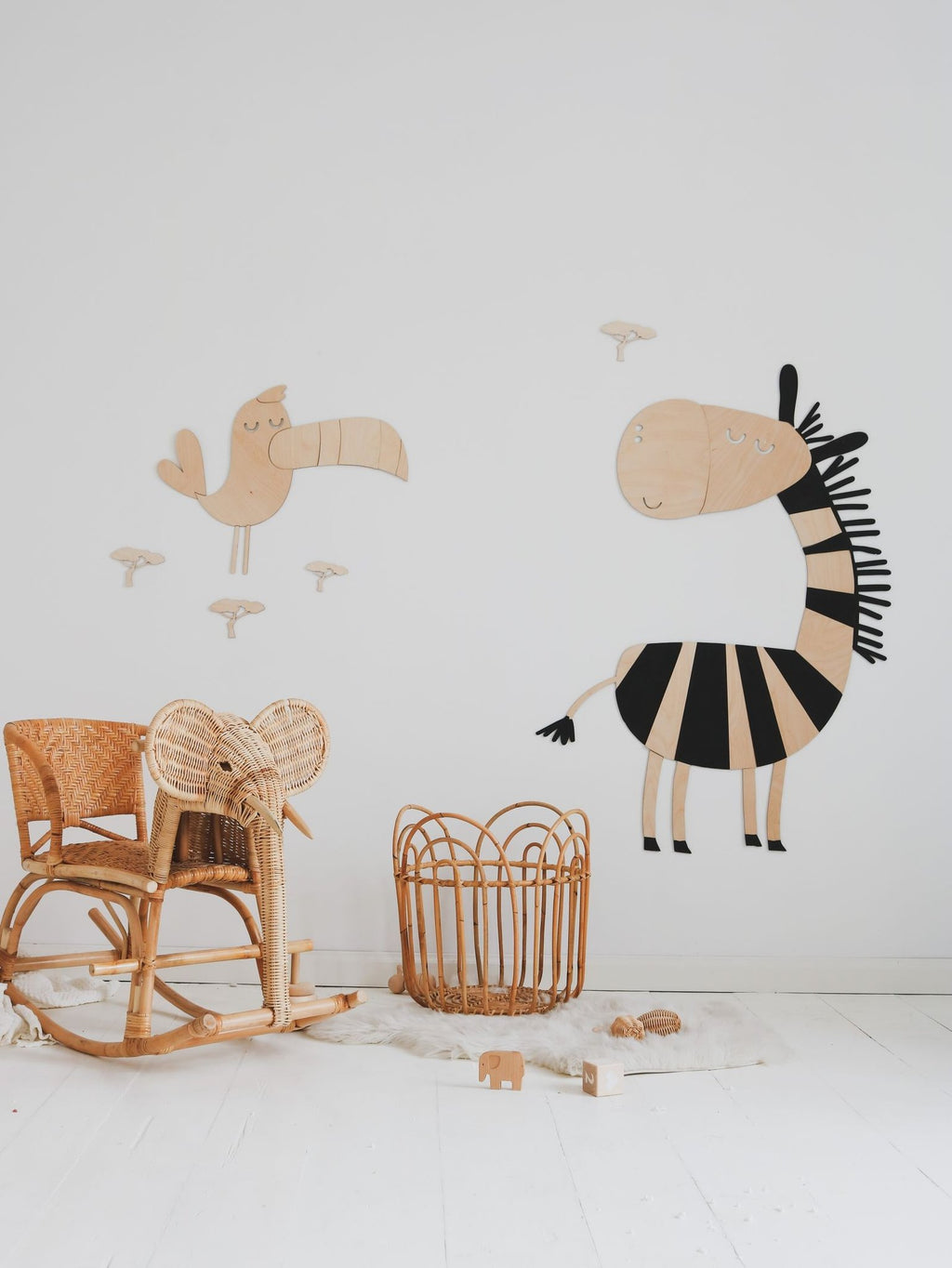 3. Wooden zebra wall decoration in a minimalist room with a wicker chair and basket, alongside a wooden bird decoration