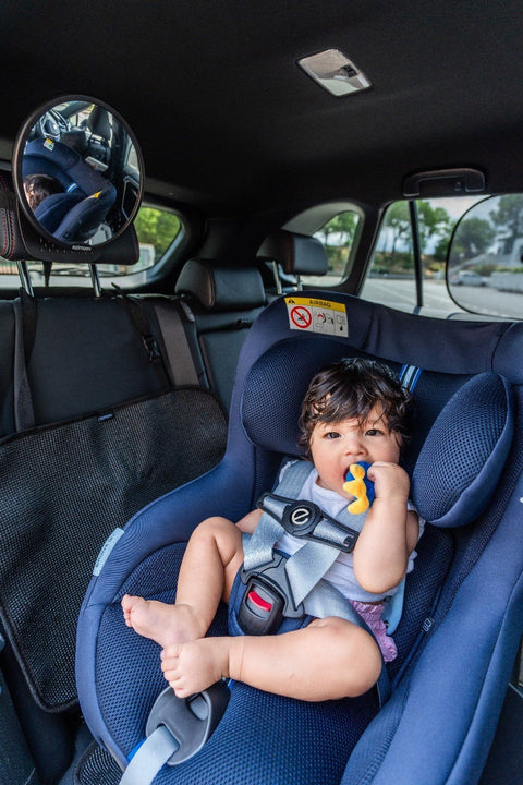 1. Child seated in car seat with Ezimoov safety clip attached to harness, ensuring secure positioning