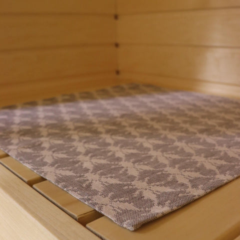1. Sauna bench seating pad with Hiiumaa fly pattern in beige and grey on wooden bench