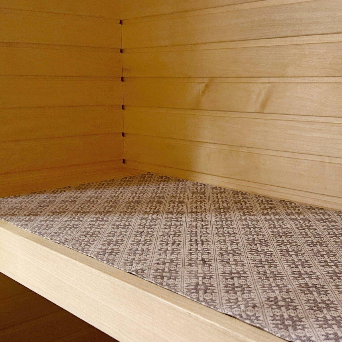3. Sauna bench seating pad with Pärnu County mitten pattern displayed on wooden bench