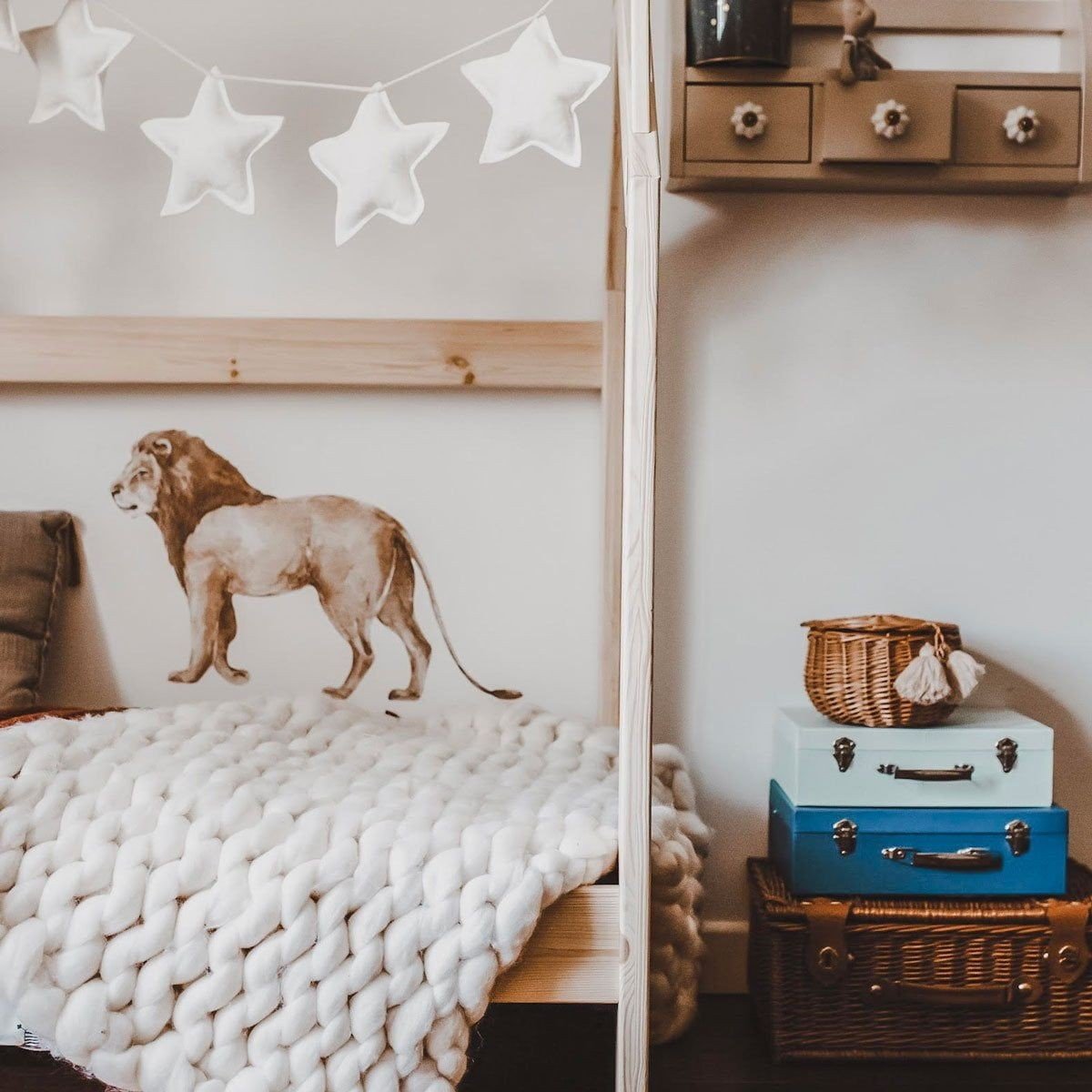12. Child's room with Savanna Wonderland wallsticker of lion on wall above bed with star garland