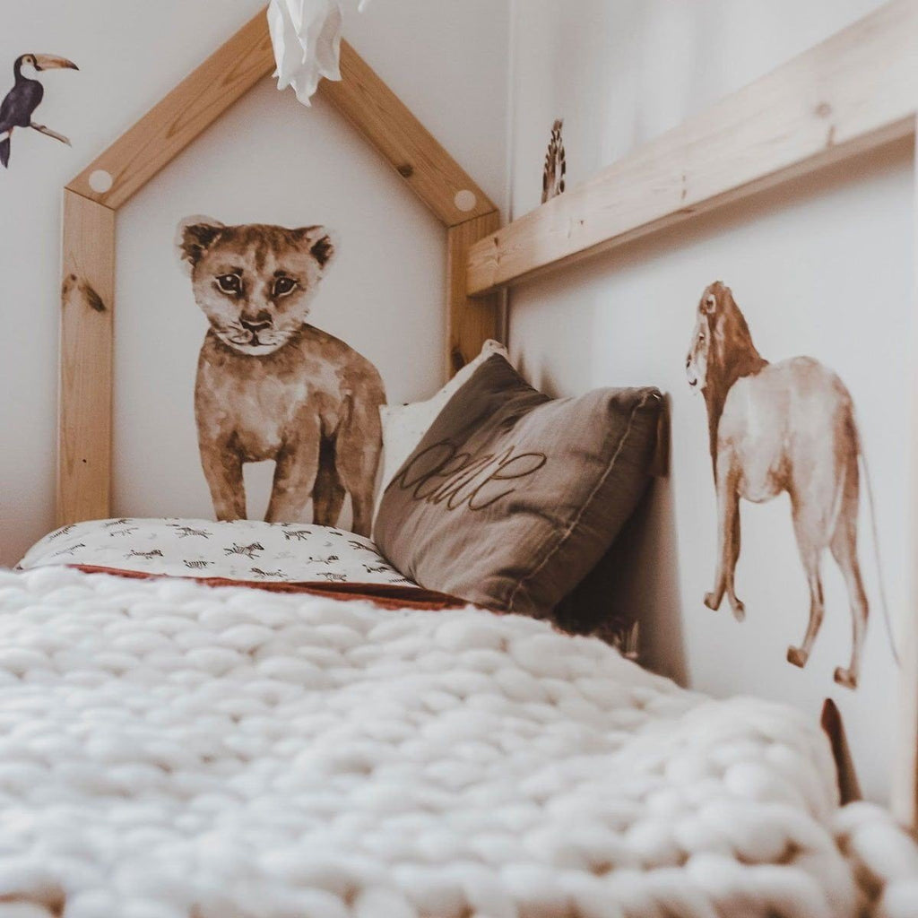 7. Wooden bed with Savanna Wonderland wallstickers of lion cub and giraffe, cozy bedding