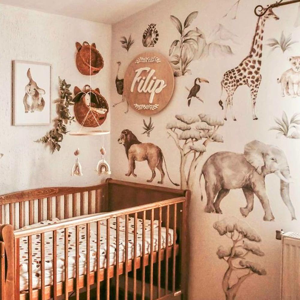 5. Nursery with Savanna Wonderland wallstickers of giraffe, elephant, and lion around crib