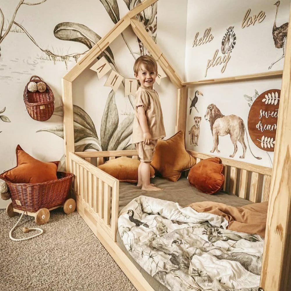 6. Child's room with Savanna Wonderland wallstickers of lion and giraffe, wooden bed, and decorative pillows
