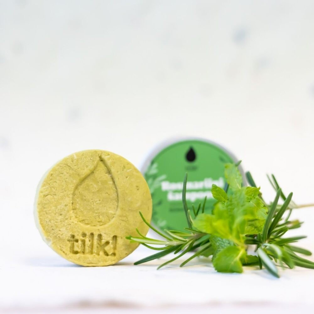 1. Tilk! Deep-Cleansing Solid Matcha Shampoo bar with rosemary and mint, shown with fresh herbs