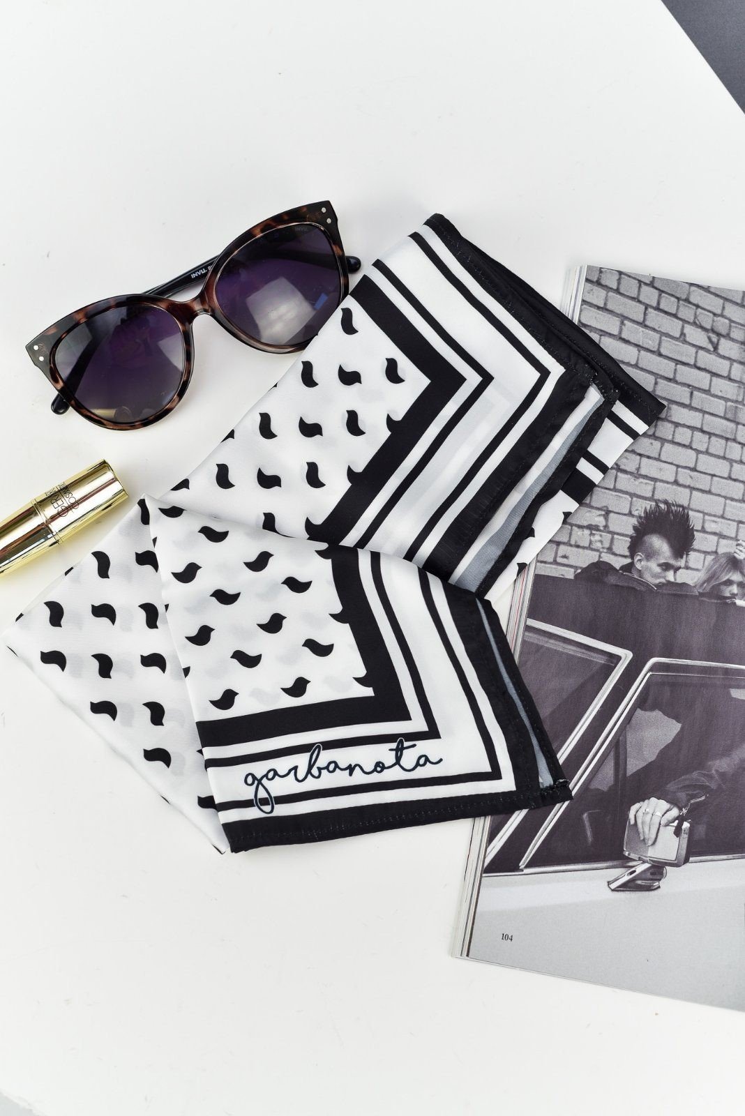 3. Close-up of Garbanota Scarf Black Birds with brand logo, featuring black bird pattern and luxurious polyester fabric