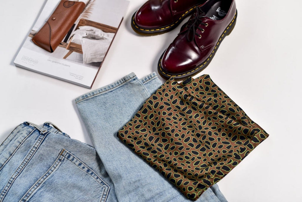 4. Flat lay of Garbanota Scarf Curly Little Leopard with denim jeans and shoes, highlighting versatile styling