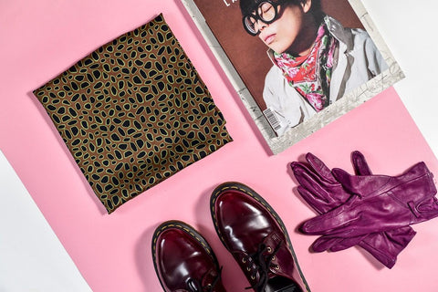 3. Flat lay of Garbanota Scarf Curly Little Leopard with magazine, purple gloves, and shoes on pink background