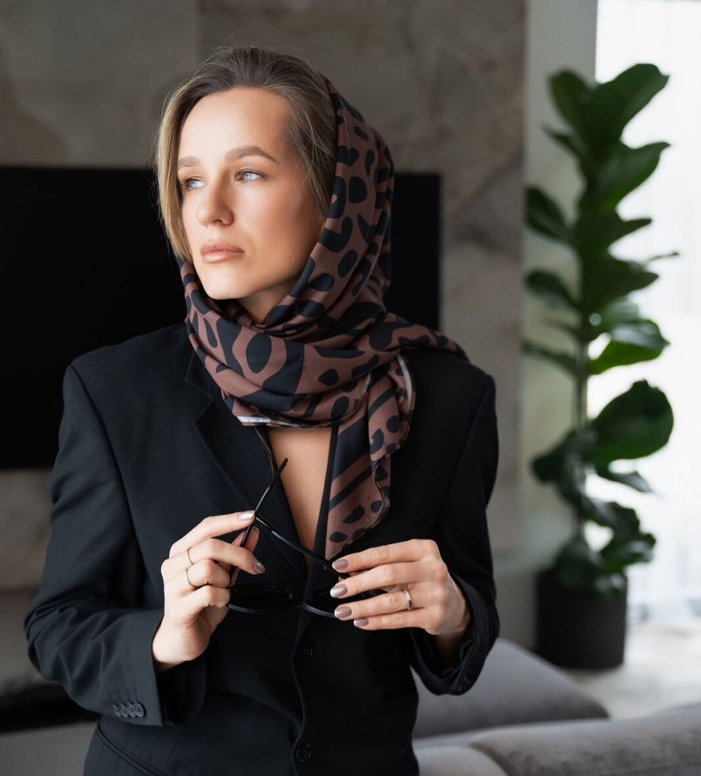 2. Women's Classic Leopard Scarf by Garbanota styled elegantly as a headscarf, paired with a black blazer in a lifestyle setting