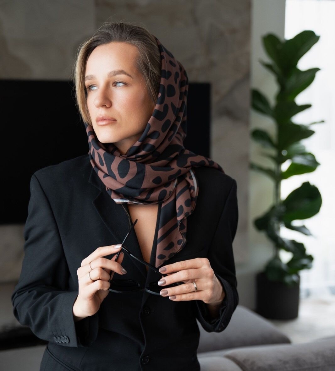 2. Women's Classic Leopard Scarf by Garbanota styled elegantly as a headscarf, paired with a black blazer in a lifestyle setting